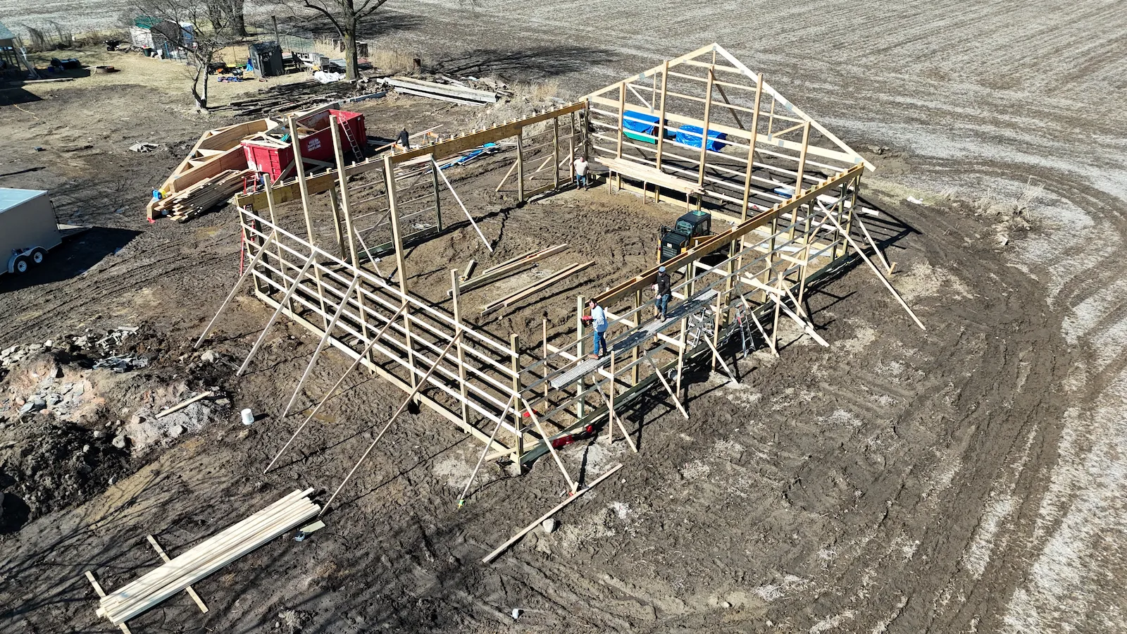 Owosso barn build — wall framing and ridge beam in progress, crew on site